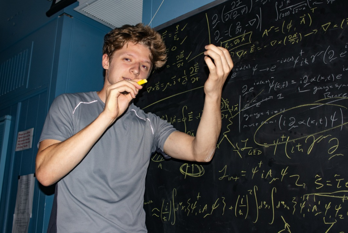Maximilian Slavik working through gauge theory on a blackboard